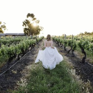 A Stunning Bride Walking Through A Winery