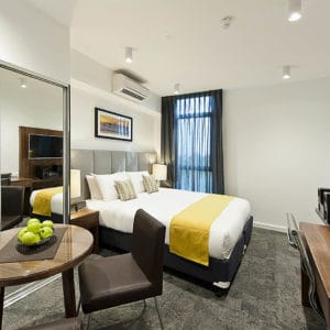 A Beautiful Hotel Bedroom With Flat Screen TV And Fruit Bowl.