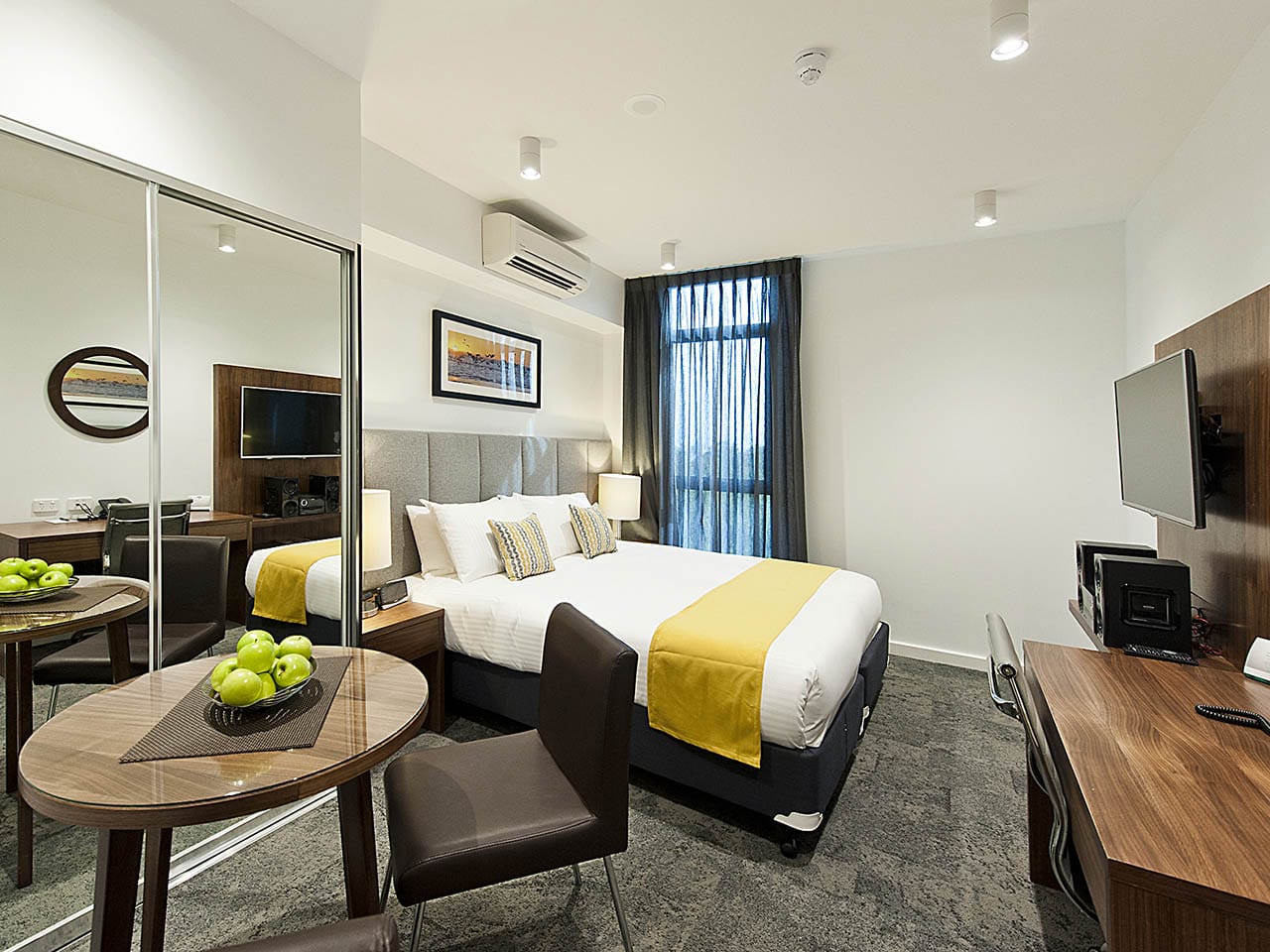 A Beautiful Hotel Bedroom With Flat Screen TV And Fruit Bowl.