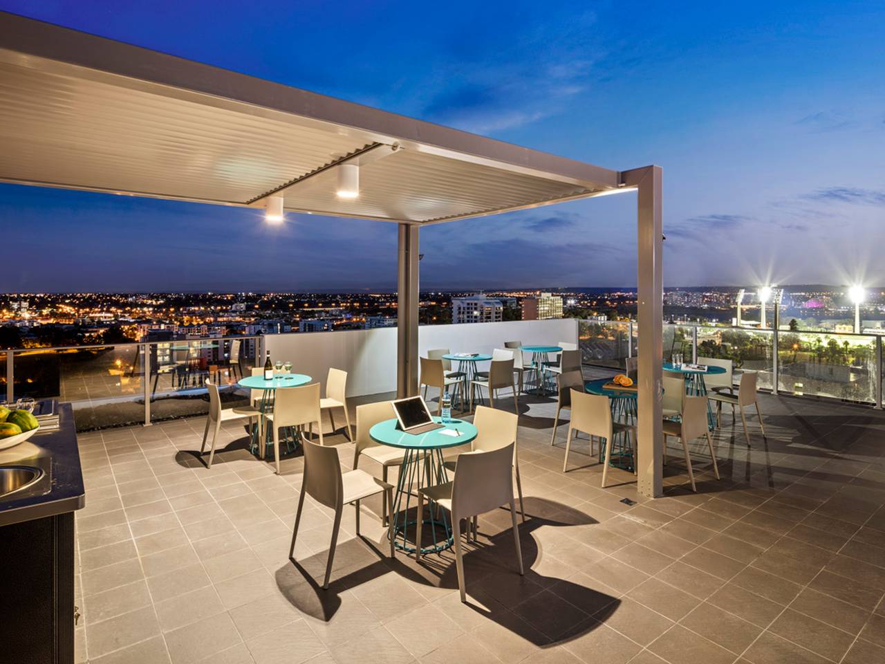 Rooftop Venue Overlooking Perth City Set Up With Tables And Chairs At Night.