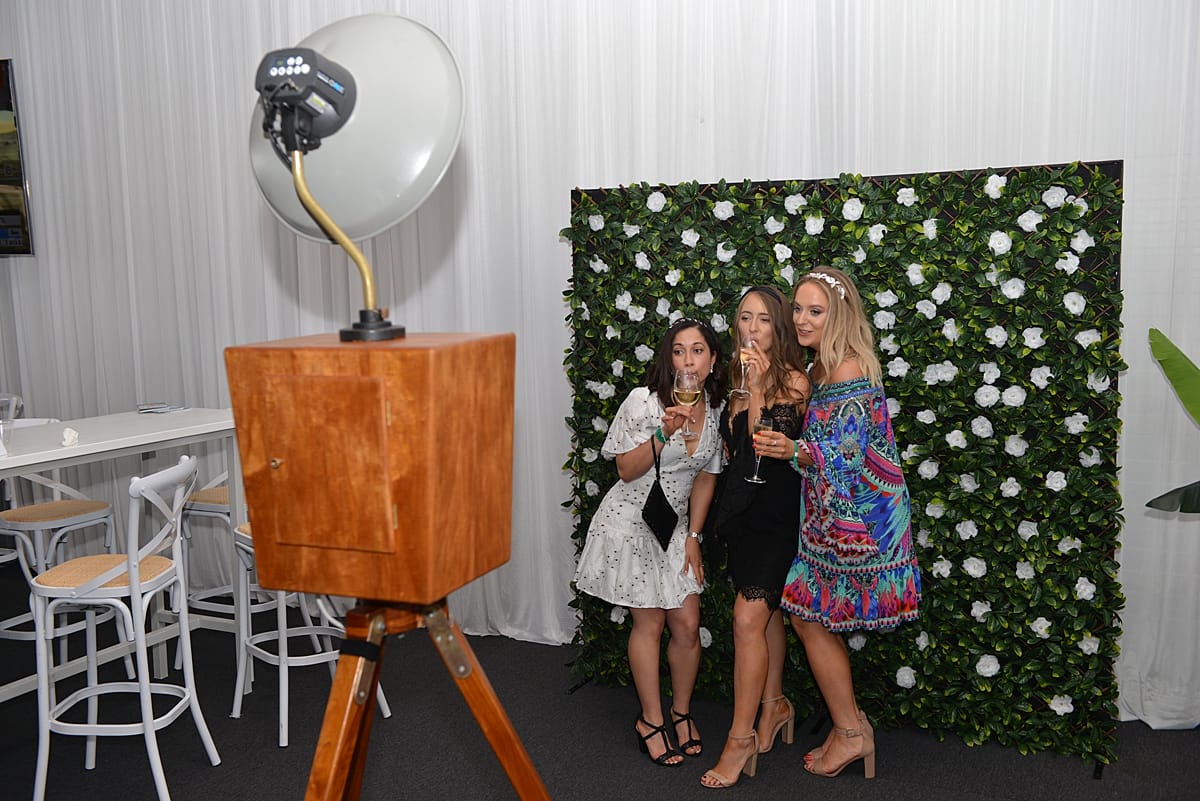 girls taking pictures at the photo booth