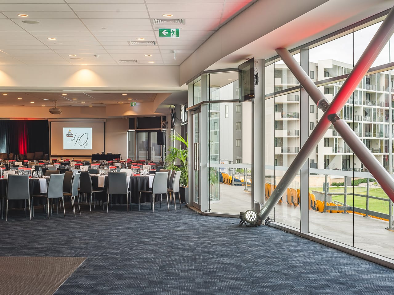 Inside The Function Room With Chairs And Tables In Banquet Style, Projection Screen And Outside View On The Right Side