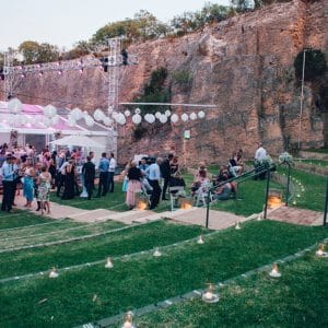 People Gathering Outside The Function Room In Dusk With Cocktail Tables And Round Hanging Lights