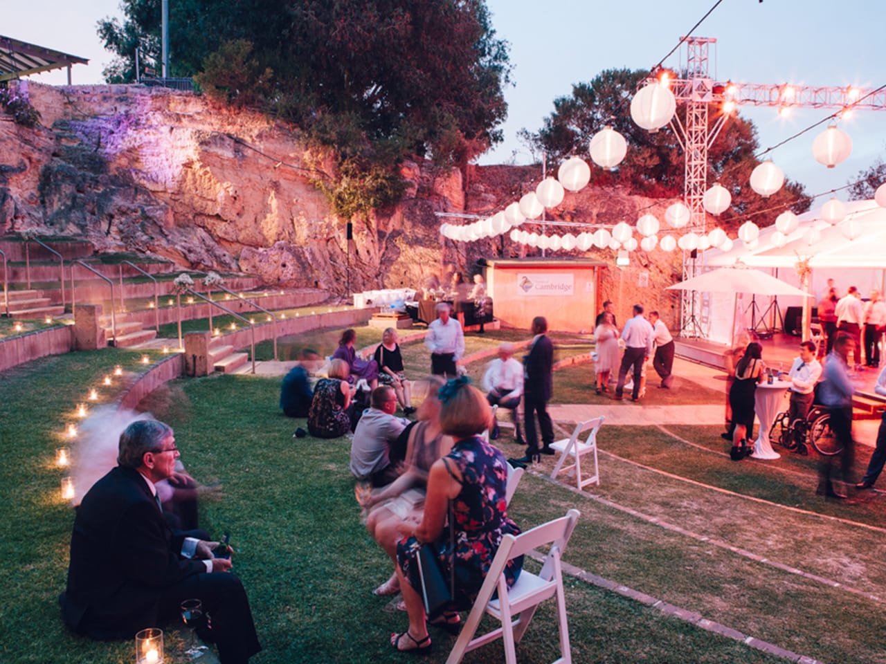 People Gathering Outside The Function Room In Dusk With Chairs And Cocktail Tables And Round Hanging Lights