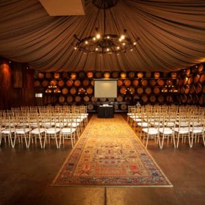 Conference Setup Inside The Function Room With Wine Casks As Wall With Projection Screen And A Chandelier