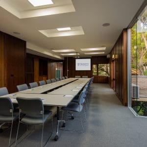 Tables And Chairs In Boardroom Setup Inside The Function Room With Projection Screen And Garden View
