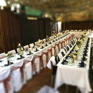 Long Tables Fully Set With Cutlery and Green Napkins In The Open Air Function Space