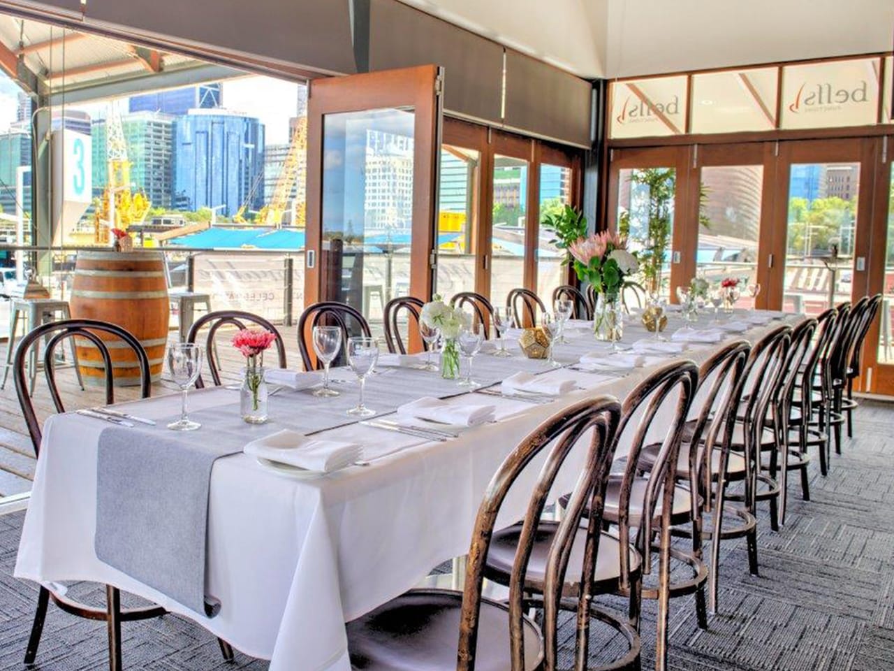 Chairs And Long Tables Setup For An Event Inside The Function Venue Perth With Glass Windows And A Balcony Behind