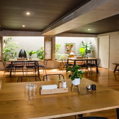 Wooden Tables With Chairs And Indoor Plants Inside The Function Room