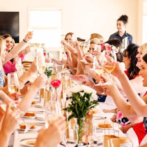 Guests Enjoying Their Drinks While Sitting On The Long Table