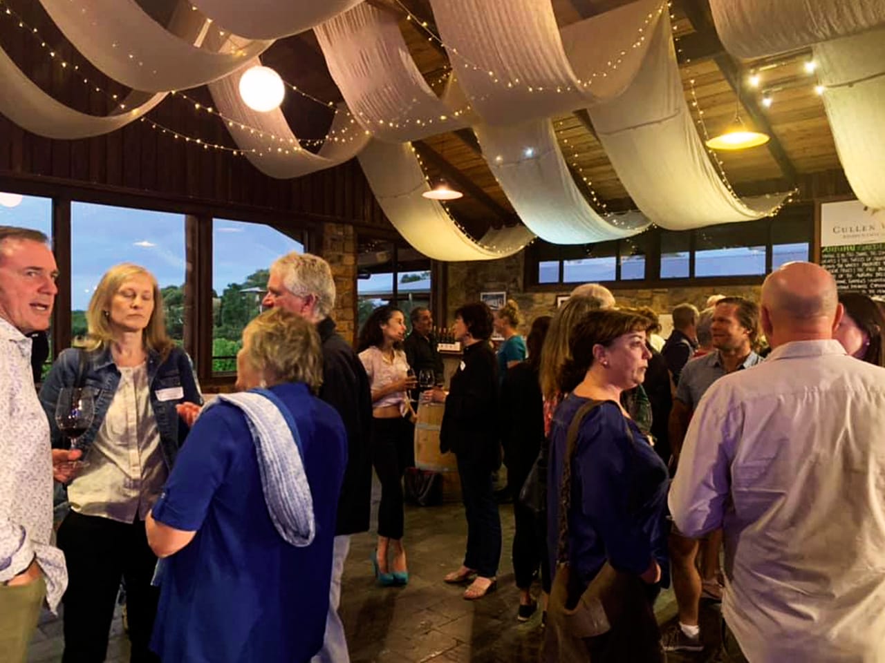 Guests Enjoying Their Drinks In An Event With Ceiling Draping Inside The Function Room