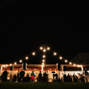 Guests Enjoying The Evening Outside The Function Room With String Lights