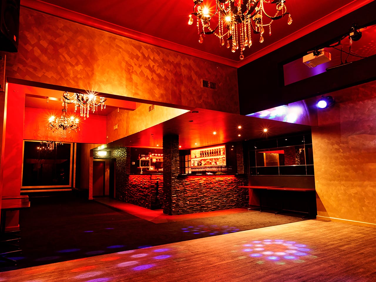Empty Function Room With Chandelier In Red Lighting And A Dance Floor