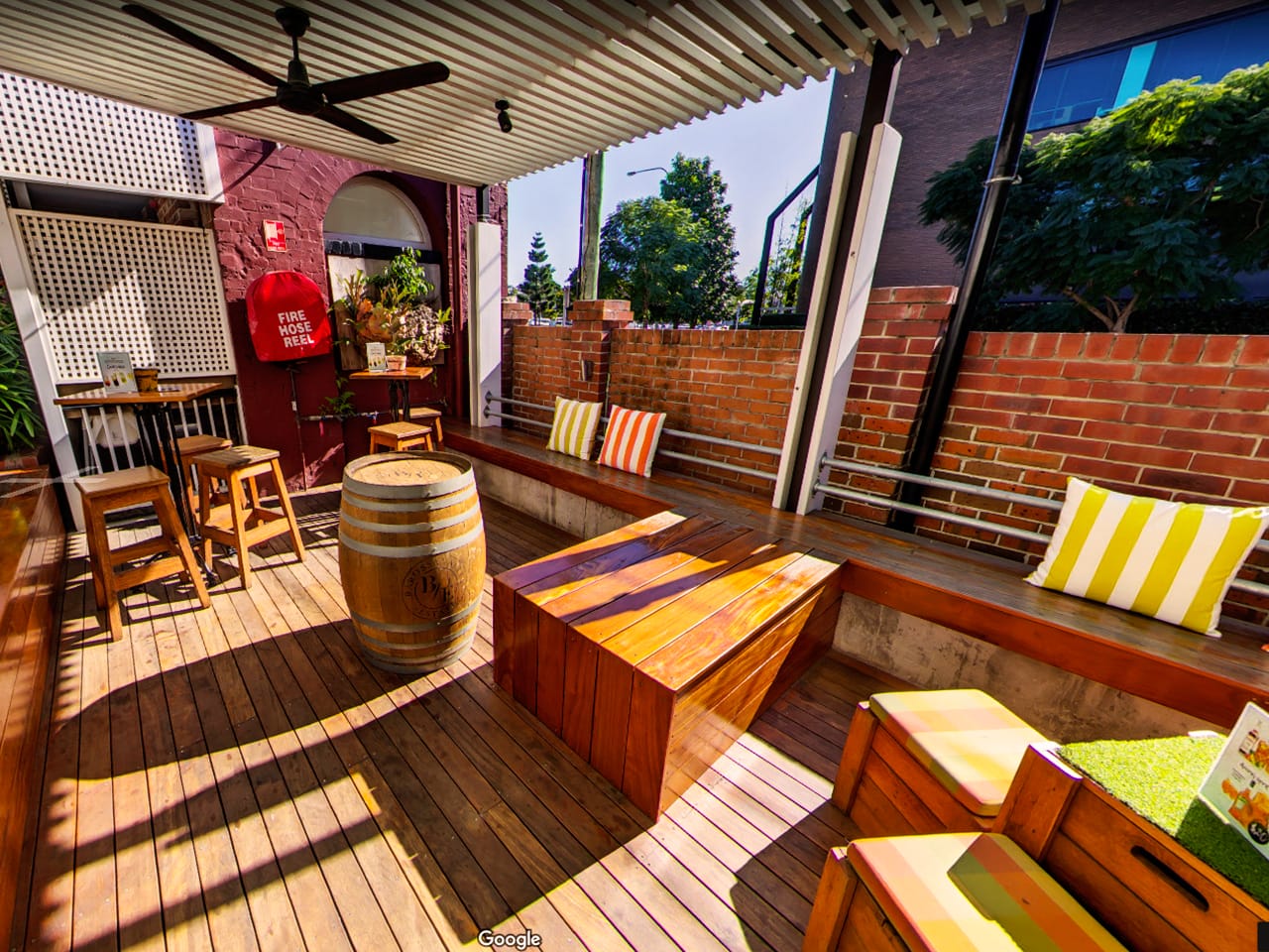Wooden Chairs And Tables With Wine Cask, A Long Chair On The Side And Stripe Pillows In The Garden Function Space