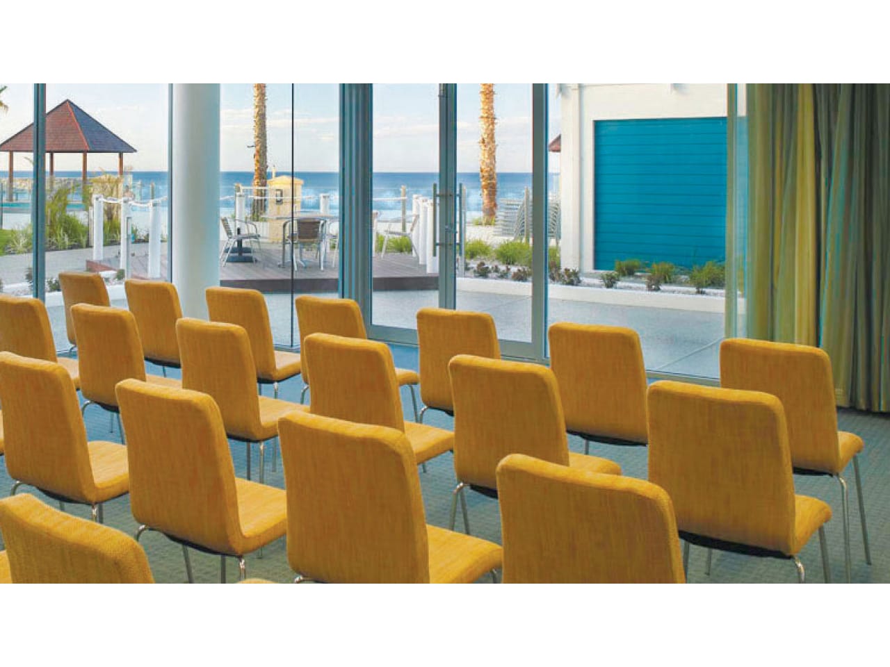 Rows of yellow seats ready for a conference with ocean views