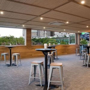 Empty function space overlooking city with round tables and bar stools
