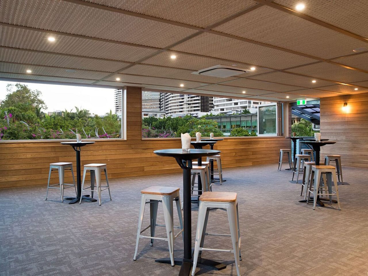 Empty function space overlooking city with round tables and bar stools