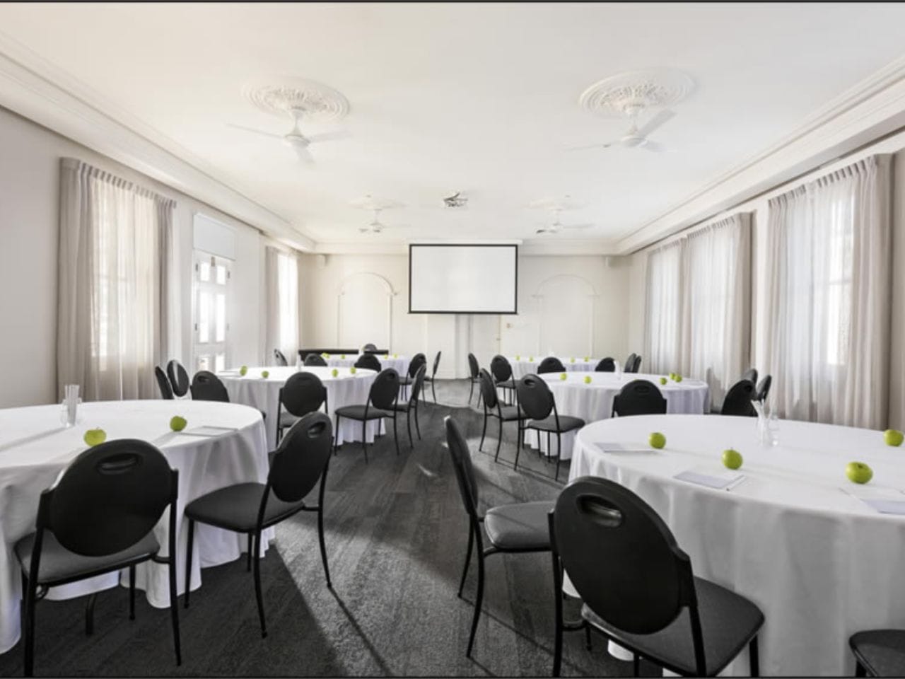 Function room with circular tables and projector screen