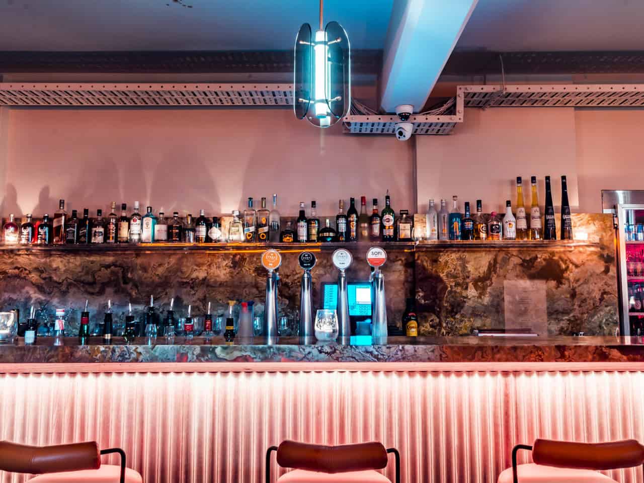 Bar area with shelves with bottles and neon lighting